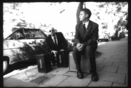 Chris and Alex crouched by speakers on a sunny day in Ballard. This photo by Josh Keller is the cover of the rebreather cd.