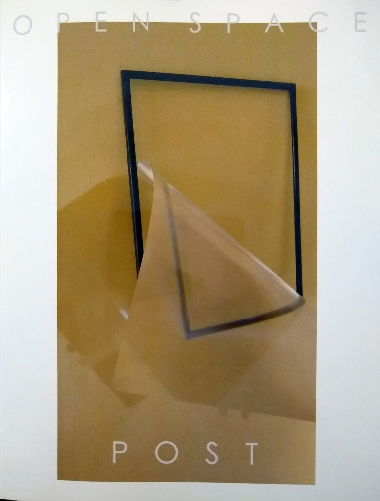 cover of The Open Space magazine number 23+24 shows a black empty frame against a beige background and transparent plastic sheet falling out of the frame.